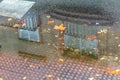 Building reflected in a puddle of water on a street in autumn