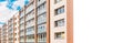 The building,renovated block of flats overlooking balconies.Renovated apartment building,front facade.Banner,white billboard,