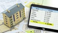 BUILDING RENOVATION COST ESTIMATE WITH BLUEPRINTS AND BUDGET ON TABLET - Architectural model with a digital spreadsheet Royalty Free Stock Photo