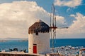 Building with sail and straw roof in Mykonos, Greece. Windmill on mountain landscape on sky. Whitewashed windmill at sea Royalty Free Stock Photo