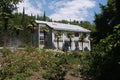 The building of the sanatorium complex against the background of a large flowerbed, beautiful palms and tall green