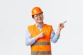 Building sector and industrial workers concept. Cheerful smiling asian builder, construction manager in helmet and