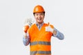 Building sector and industrial workers concept. Happy satisfied asian builder, construction manager in helmet and