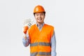 Building sector and industrial workers concept. Happy smiling asian engineer, architect in reflective clothing and