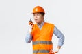 Building sector and industrial workers concept. Serious-looking busy construction manager give orders to workers and