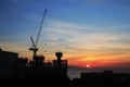 Building silhouettes and Industrial construction cranes on beautiful sunset Royalty Free Stock Photo