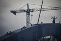 Building site crane behinf bridge with pigeons and electicity monument in Vilnius, Lithuania Royalty Free Stock Photo