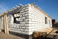 Building site of a house under construction. corner unfinished house walls made from white aerated autoclaved concrete blocks