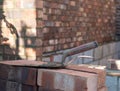 Marshalltown trowel in mortar cement and bricks for brickwork, part of a renovation of an Edwardian house in north London, UK