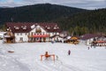 Building of the ski resort Mountain Salanga with people resting in the foothills of the Kuznetsk Alatau mountains