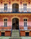 a building with stairs up to some bushes and flowers in front Royalty Free Stock Photo