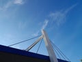 The building supports the bridge with three strong and sturdy steel cables against a beautiful blue sky background.