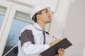 Building surveyor writing on clipboard on construction site