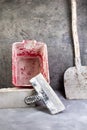 Building tools old, dirty shovel , red bucket, bricks on the gray concrete background. Copy space. Top view Royalty Free Stock Photo