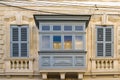 Building with traditional maltese balcony in historical part of Mosta. Window on the facade of a house in Malta