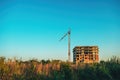 Building under construction and crane machinery against sunset sky Royalty Free Stock Photo