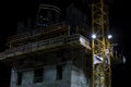 Building under construction with crane mast at night side Royalty Free Stock Photo