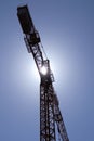 building under construction with scaffolding, yellow crane and blue sky