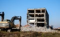 Building under demolition with hydraulic excavator Royalty Free Stock Photo