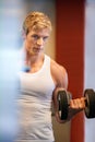 Building up his upper body strength. Handsome blonde man looking up while lifting weights. Royalty Free Stock Photo