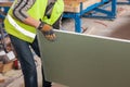 Building a wall for frame house. Worker holding a drywall. Royalty Free Stock Photo