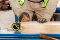 Building a wall for frame house. Worker make marks for cutting timber.