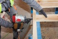 Building a wall for frame house.Worker use Framing Nailer to attach wooden beams. Royalty Free Stock Photo