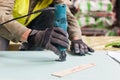 Building a wall for frame house. Worker use Laminate Trimmer for cutting drywall. Royalty Free Stock Photo