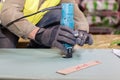 Building a wall for frame house. Worker useLaminate Trimmer for cutting drywall. Royalty Free Stock Photo