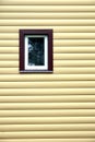 Building wall with plastic window covered with beige siding panels front view Royalty Free Stock Photo