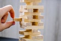 Building from wooden blocks. Game for family of wooden bars. Wood blocks stack game with Hand on background. Block tower with Royalty Free Stock Photo