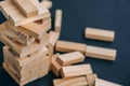 Building from wooden blocks. Game for family of wooden bars. Wood blocks stack game with Hand on background. Block tower Royalty Free Stock Photo