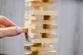 Building from wooden blocks - jenga. Game for family of wooden bars. Wood blocks stack game with Hand on background. Block tower Royalty Free Stock Photo