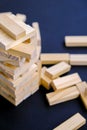 Building from wooden blocks - jenga. Game for family of wooden bars. Wood blocks stack game with Hand on background. Block tower Royalty Free Stock Photo