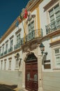 Building with wooden gate with iron balustrade and flags