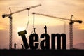 Building the Word Team with Cranes Teamwork and Collaboration Concept Royalty Free Stock Photo