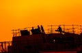 building workers working on a building under a sunset Royalty Free Stock Photo