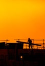 building workers working on a building under a sunset Royalty Free Stock Photo