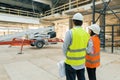 Building workers working at construction site, builders looking in blueprint, back view, copy space. Building, development, Royalty Free Stock Photo