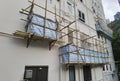 Building wrapped in traditional Chinese scaffolding made of bamboo for worker to repair or replace air conditioner above window Royalty Free Stock Photo