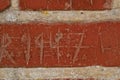 Building, writing and closeup of red, brick wall for texture, background and pattern of exterior structure. Architecture Royalty Free Stock Photo