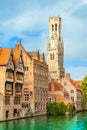 Belfry tower and old traditional houses along the canal in Bruges, Belgium. Royalty Free Stock Photo