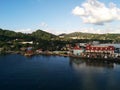 Buildings and green hills on island shore with blue sky and sea