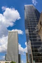 Buildings of modern city jutting up into intensely blue clouded sky with reflections Royalty Free Stock Photo