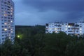 Buildings plunged in the forest lights in windows cloudy sky night view. Outskirts of Kyiv, Ukraine