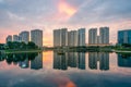 Buildings with reflections on lake at sunset at Thanh Xuan park. Hanoi cityscape at twilight period Royalty Free Stock Photo