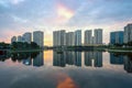 Buildings with reflections on lake at sunset at Thanh Xuan park. Hanoi cityscape at twilight period Royalty Free Stock Photo