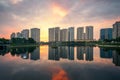 Buildings with reflections on lake at sunset at Thanh Xuan park. Hanoi cityscape at twilight period Royalty Free Stock Photo
