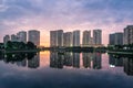 Buildings with reflections on lake at sunset at Thanh Xuan park. Hanoi cityscape at twilight period