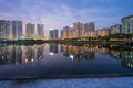 Buildings with reflections on lake at twilight at Thanh Xuan park. Hanoi cityscape at twilight period Royalty Free Stock Photo